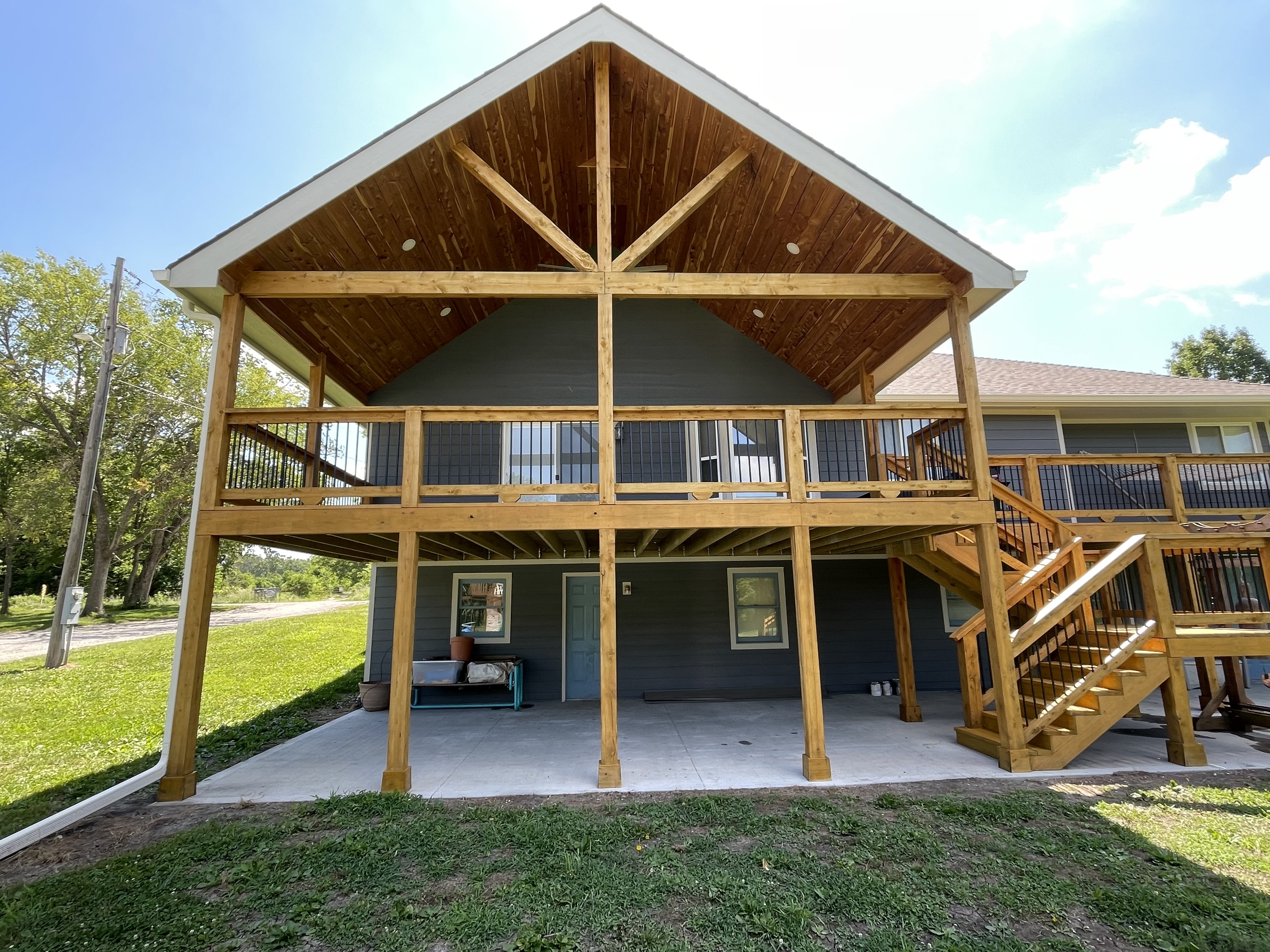 Stunning two-story stained timber back deck and ceiling in Grandview, MO by Red Letter Painting