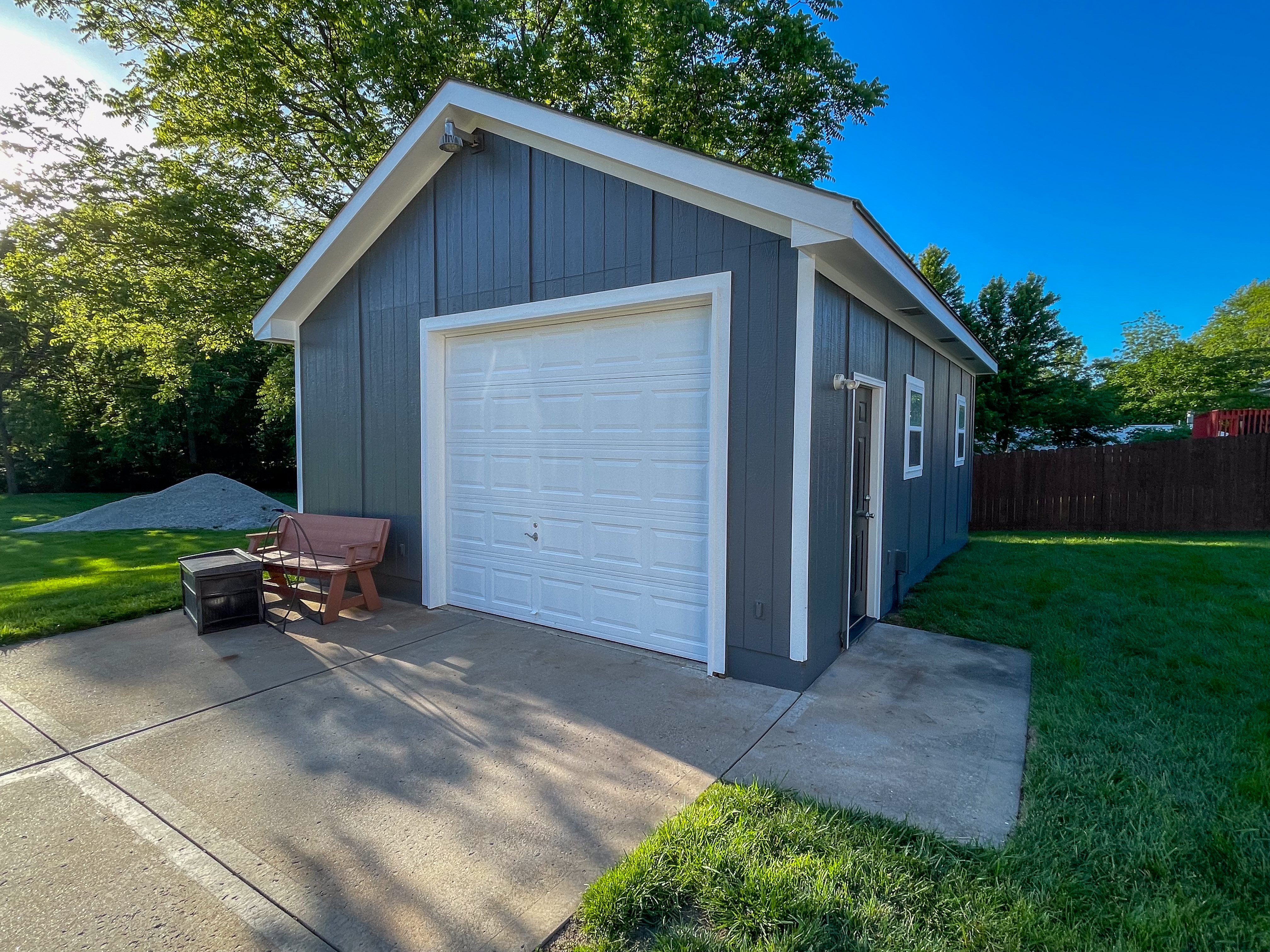 Dark gray detached garage with clean white trim in Belton, MO by Red Letter Painting